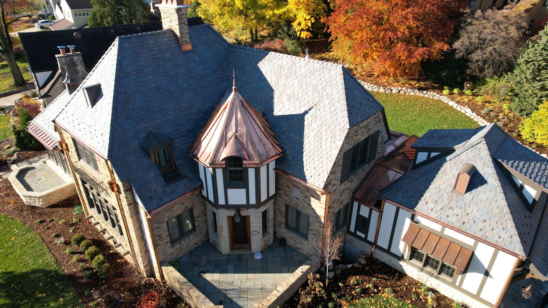 An aerial view of a large house with a copper roof.