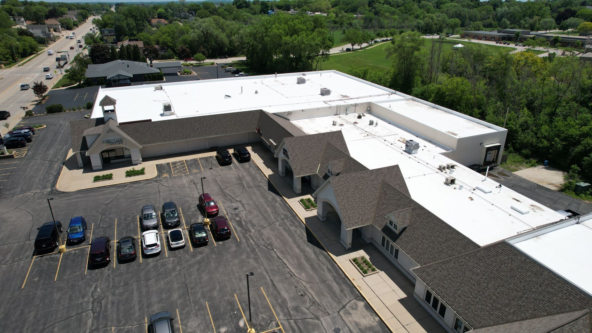 An aerial view of a large building with a white roof.