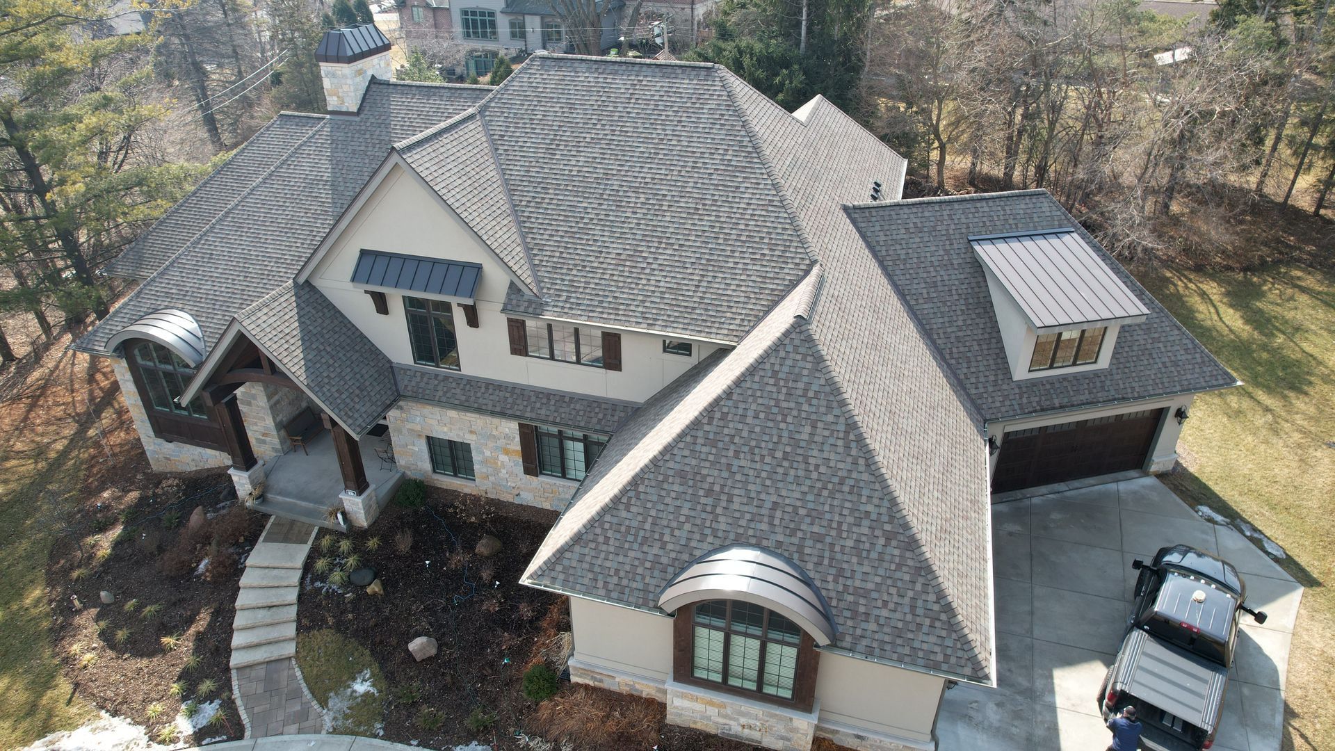 An aerial view of a large house with a car parked in front of it.