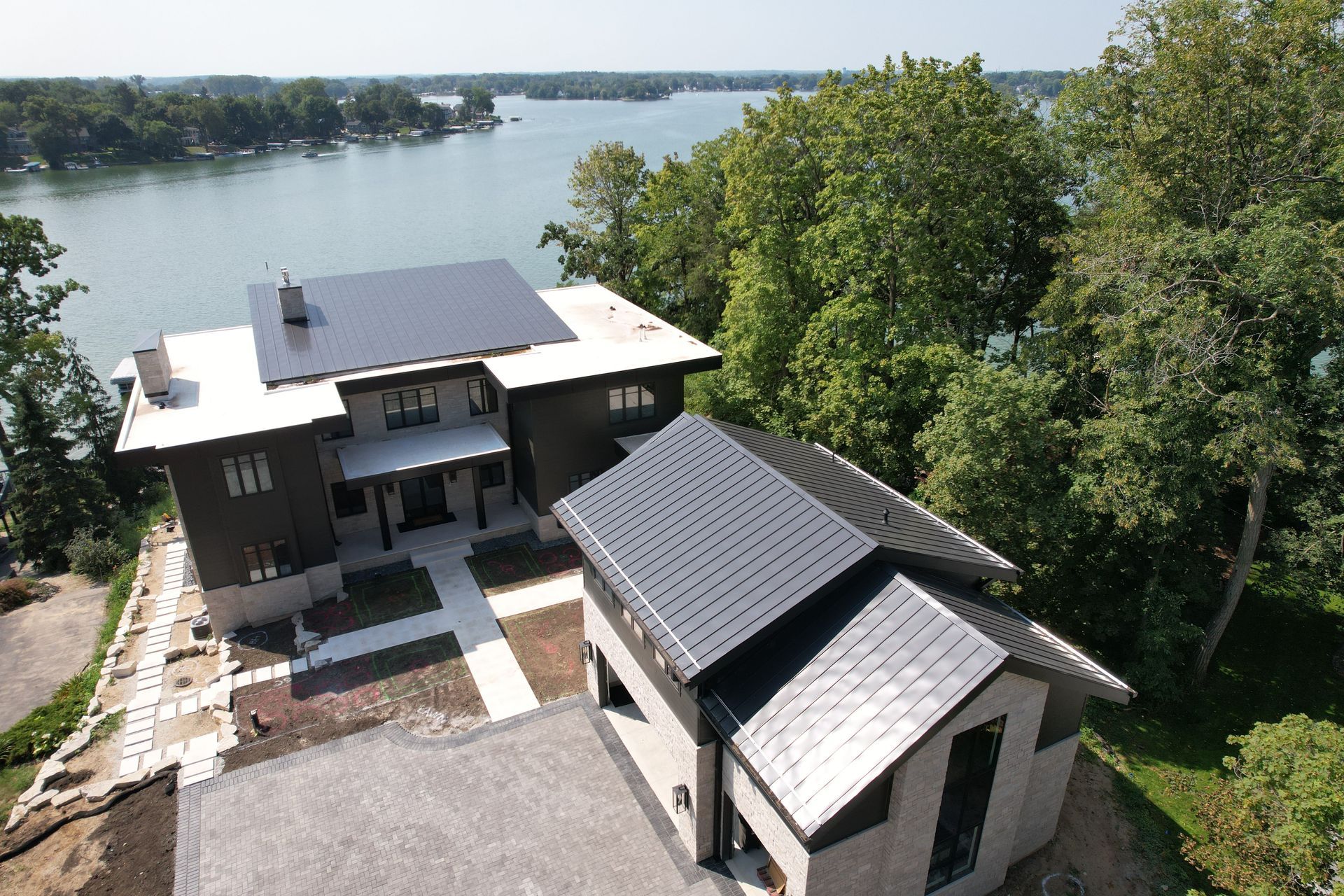 An aerial view of a house with a lake in the background.
