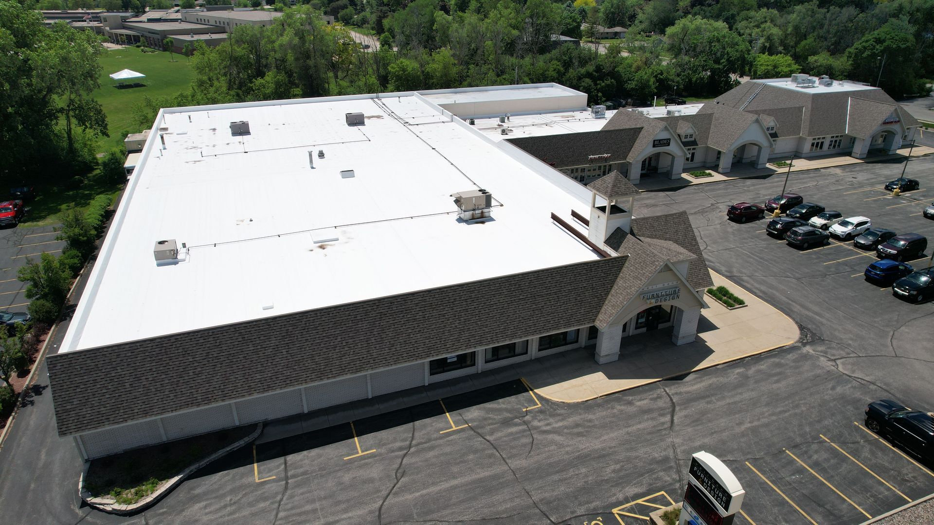 An aerial view of a large building with a white roof.