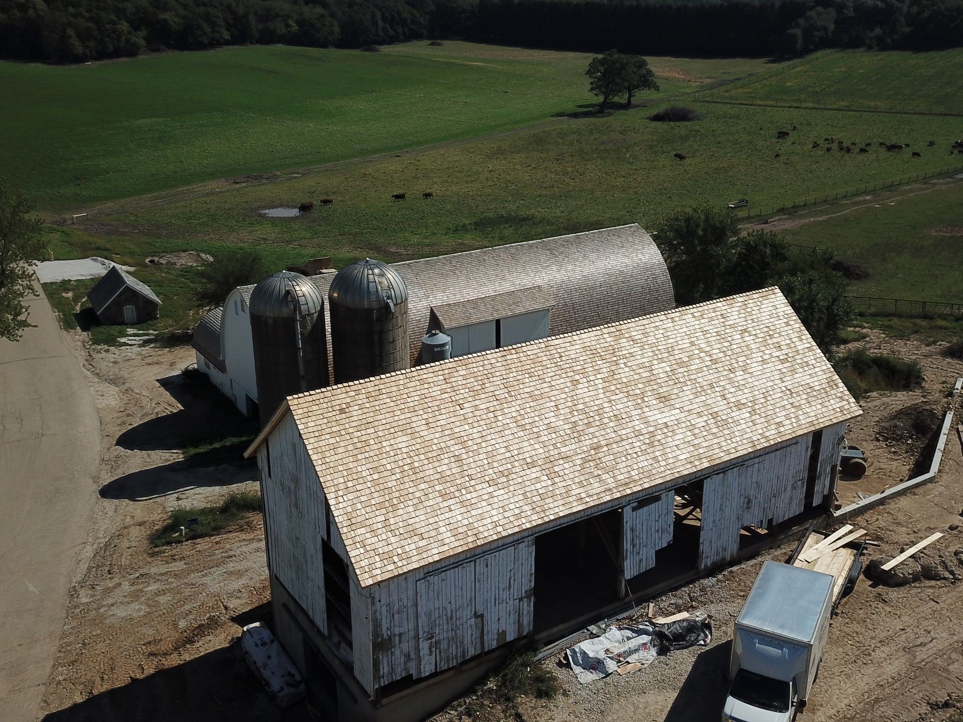 An aerial view of a barn with a truck parked in front of it.