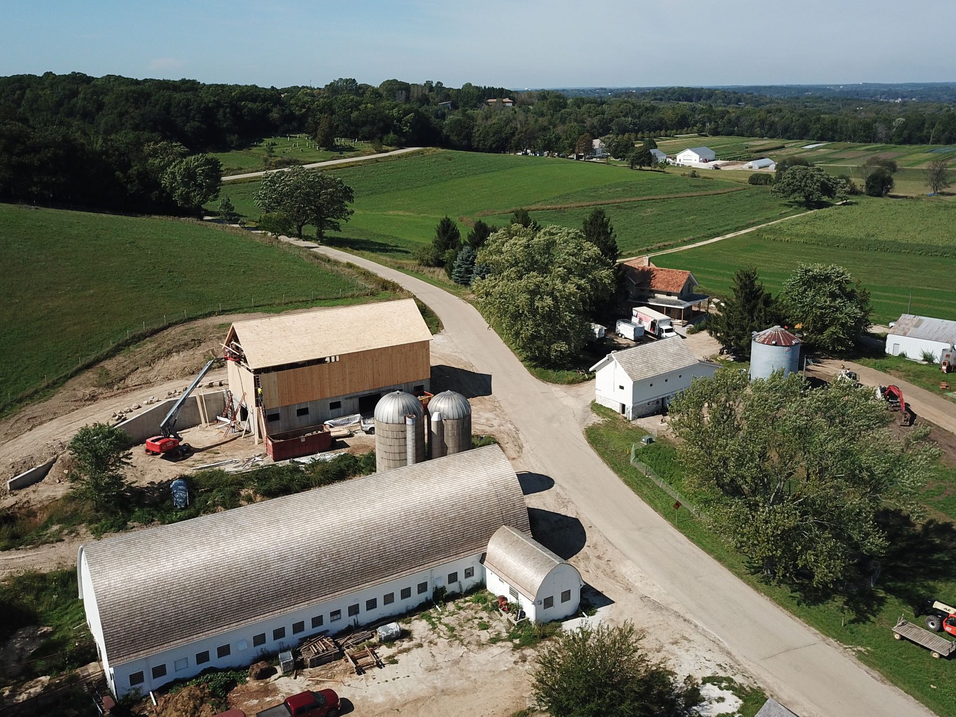 An aerial view of a farm with a barn and silos.