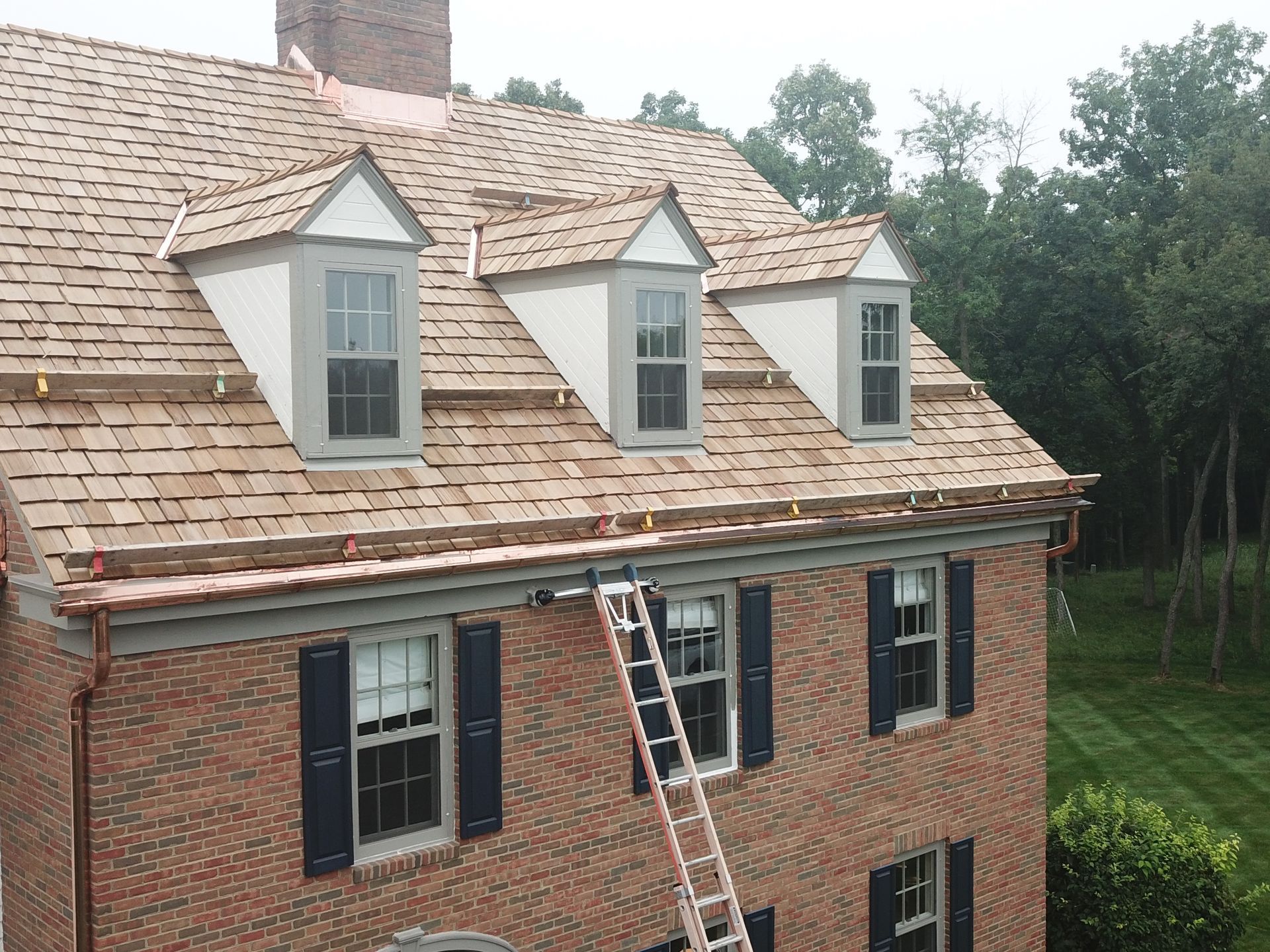 A brick house with a ladder on the side of it.