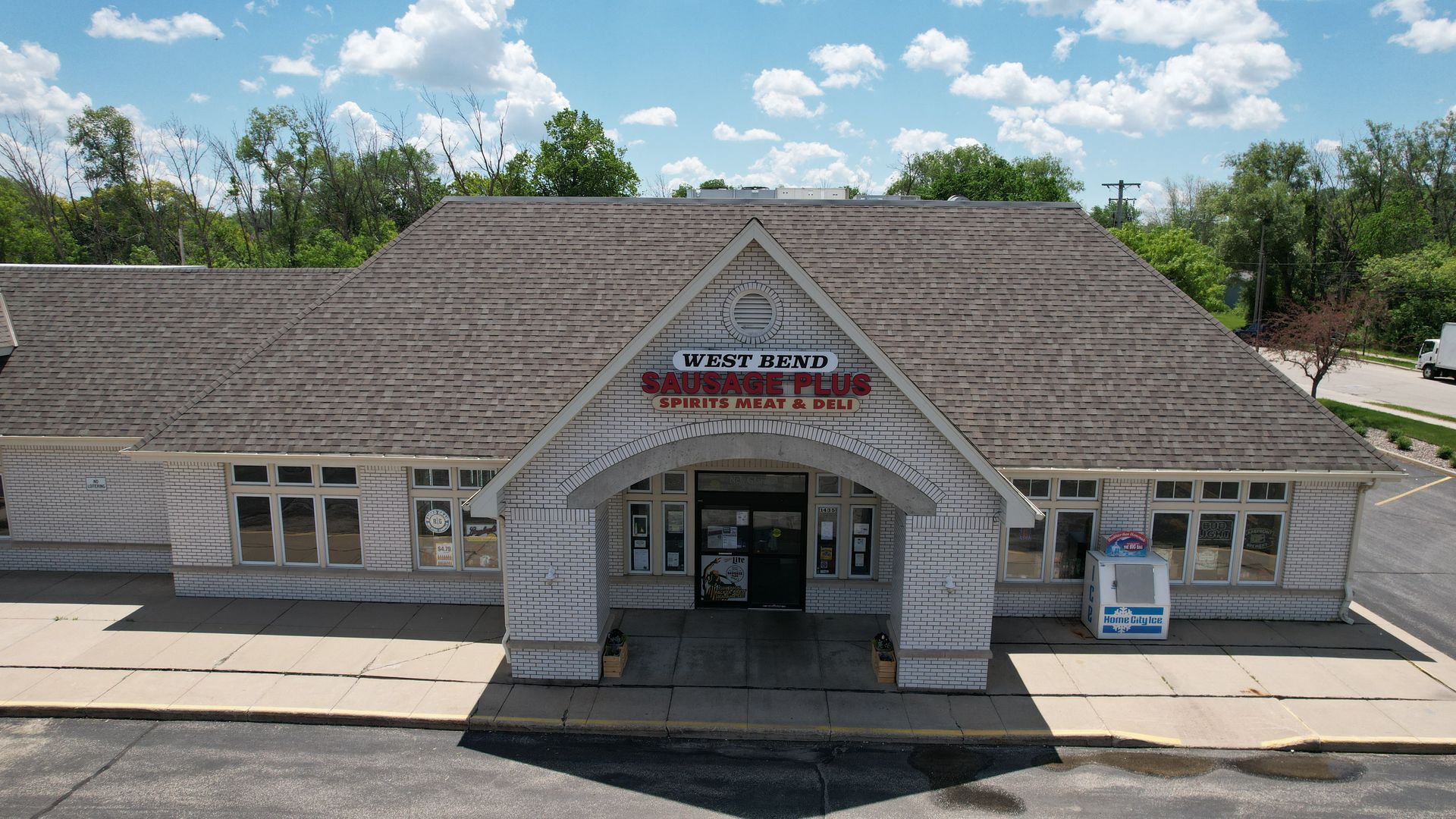 An aerial view of a white building with a gray roof.