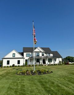 A large white house with a flag on a pole in front of it.