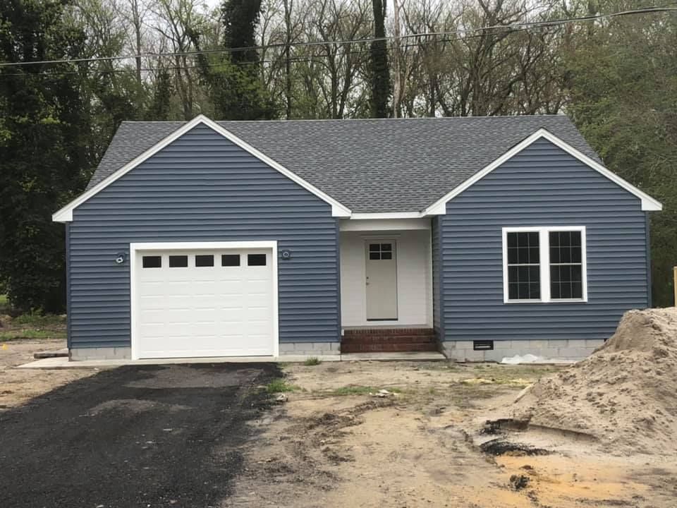 A small blue house with a white garage door