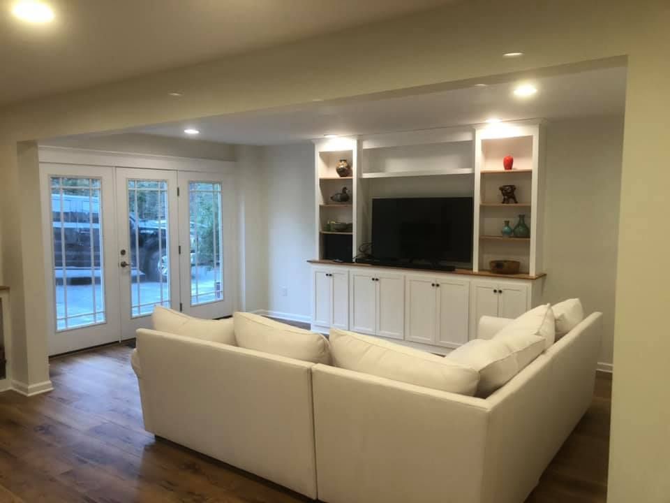 A living room with a white couch and a flat screen tv.