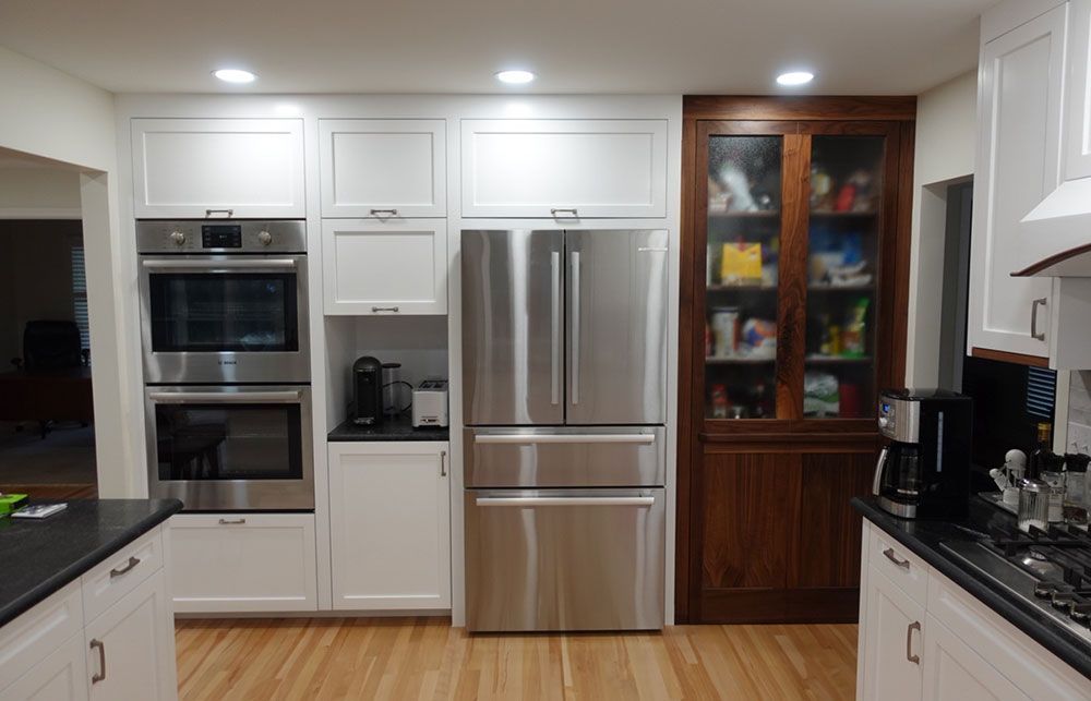 A kitchen with stainless steel appliances and white cabinets