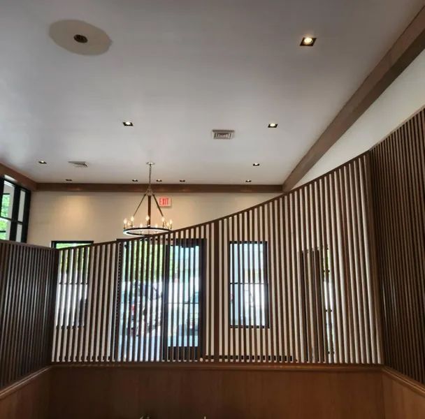 A room with a wooden divider and a chandelier hanging from the ceiling