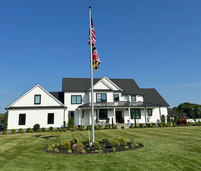 A large white house with a flag in front of it
