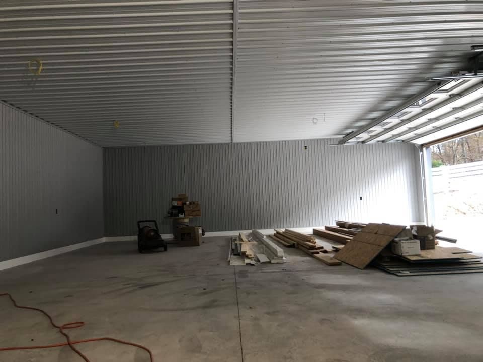 A large empty garage with a vacuum cleaner on the floor.