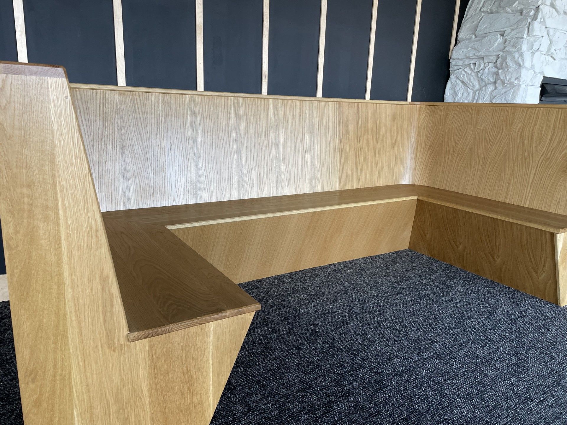 A wooden bench is sitting in a room next to a fireplace.