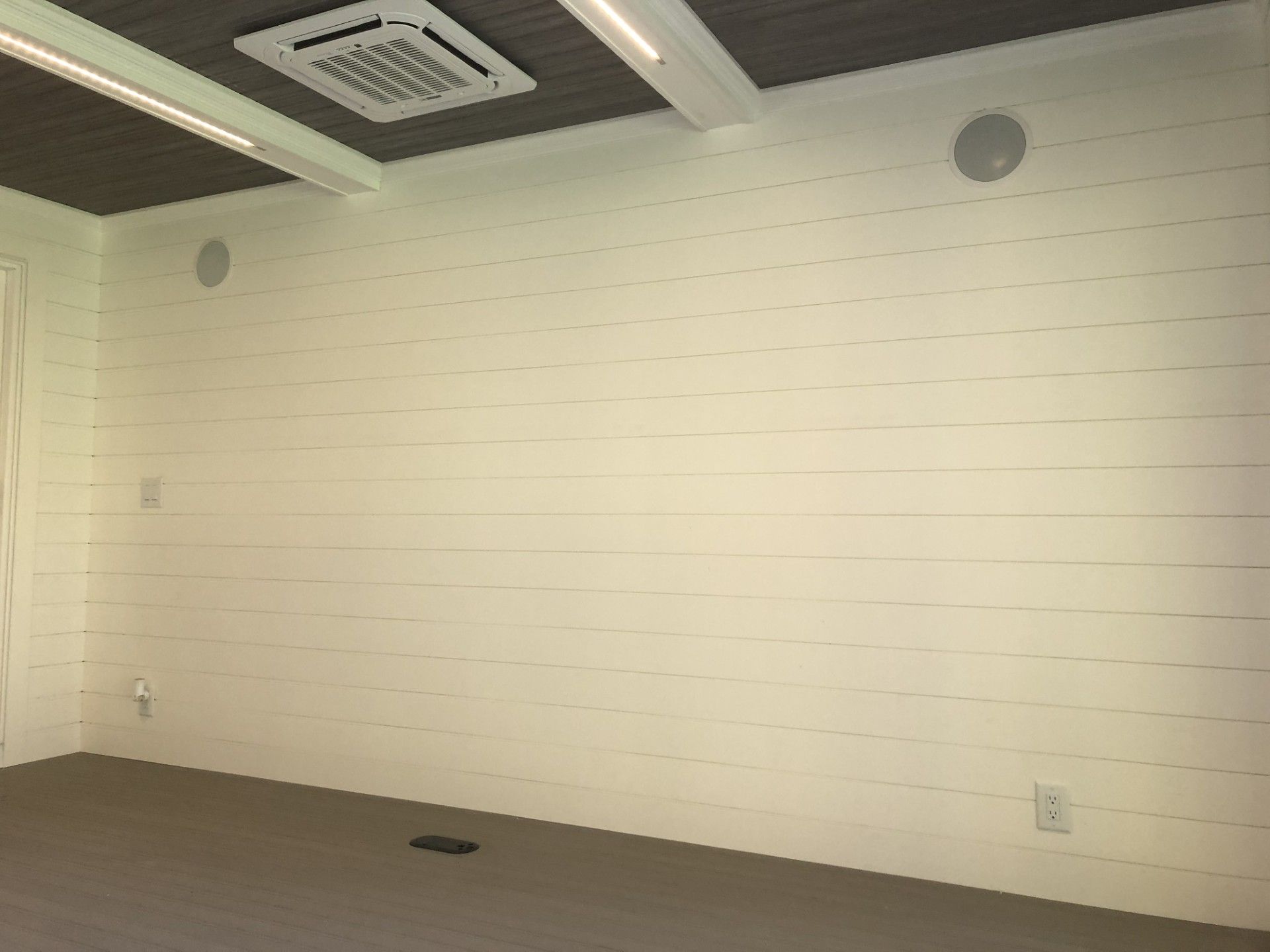 An empty room with white walls and a ceiling fan