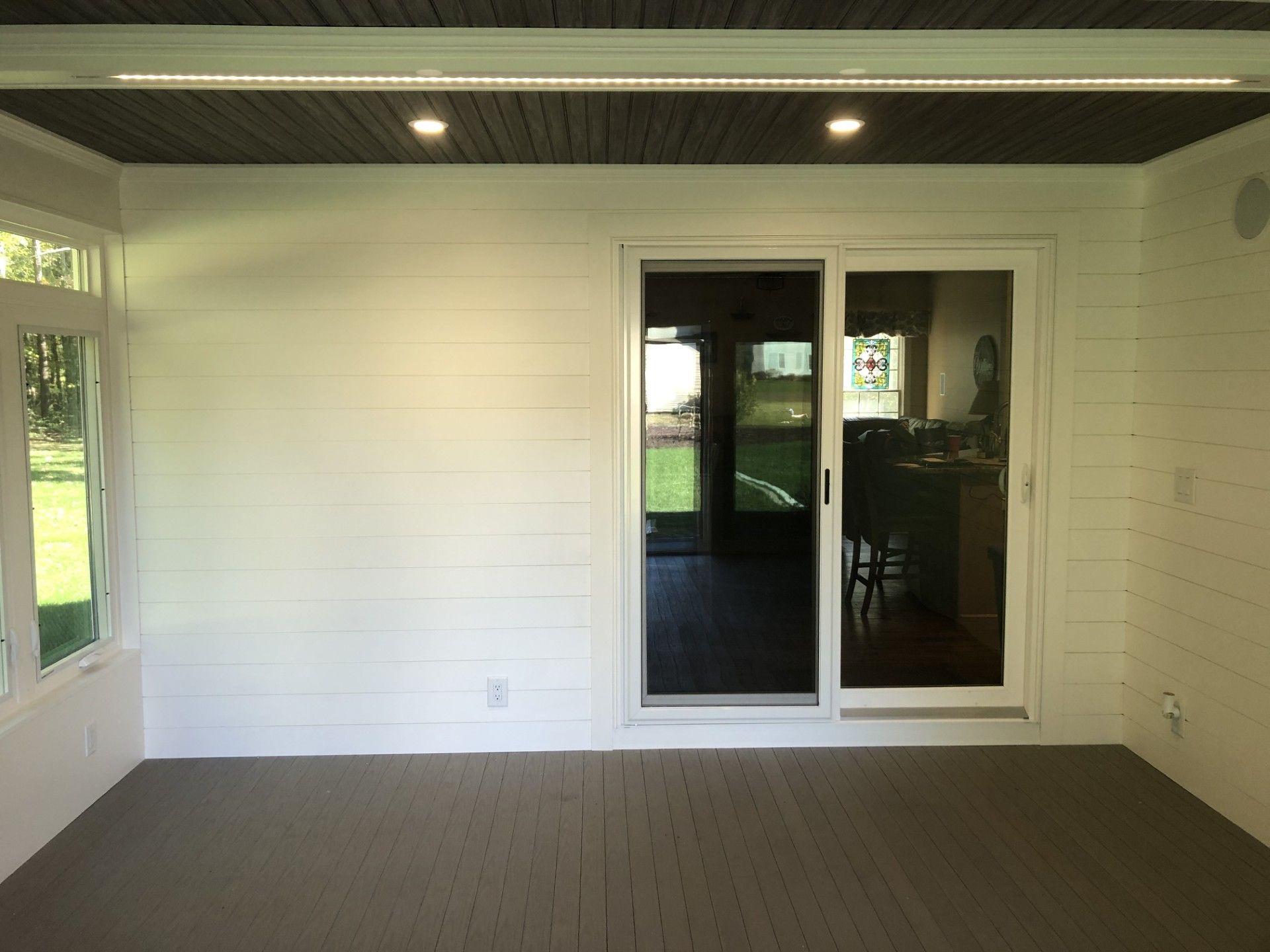 An empty room with a sliding glass door leading to a patio.