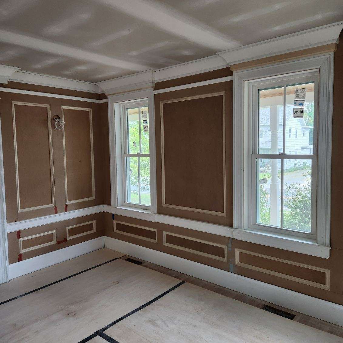 A room with a lot of windows and a wooden floor.