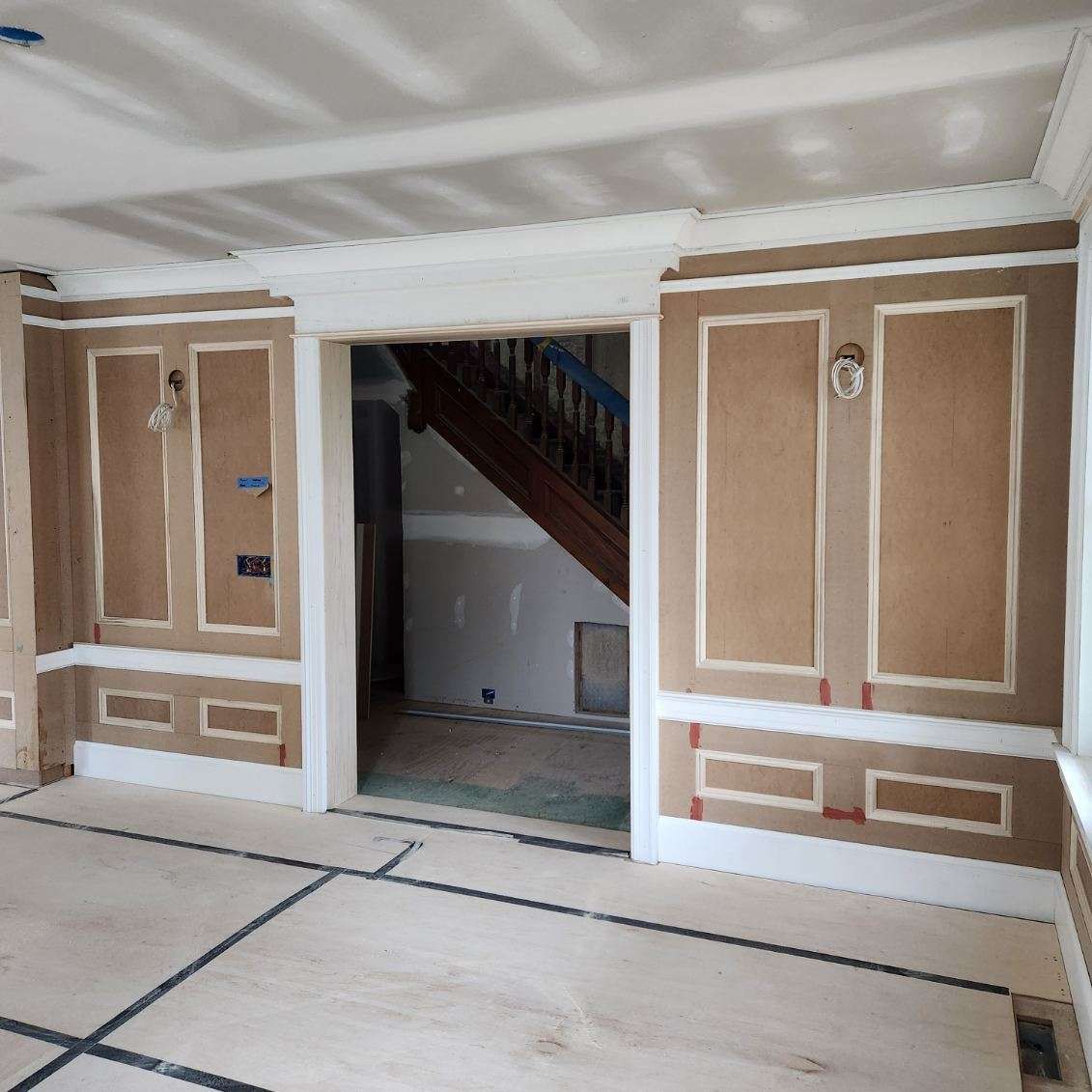 An empty room with a staircase in the background