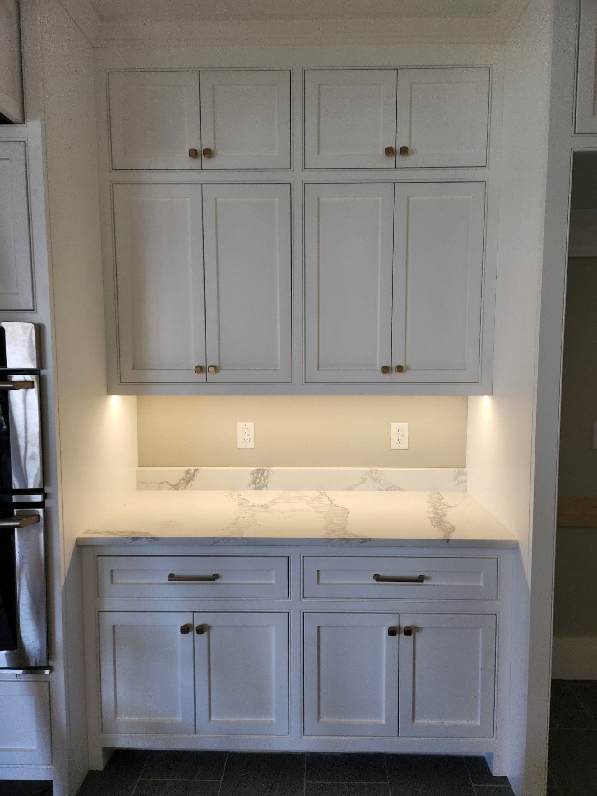 A kitchen with white cabinets and a white counter top