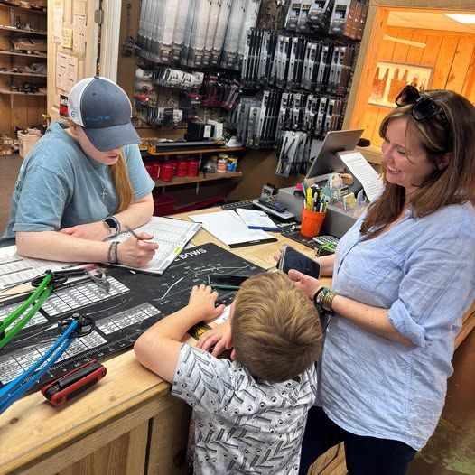 Learn More About Rentals A customer and child interact with a staff member at a store counter. The child looks on, as the staff member points.