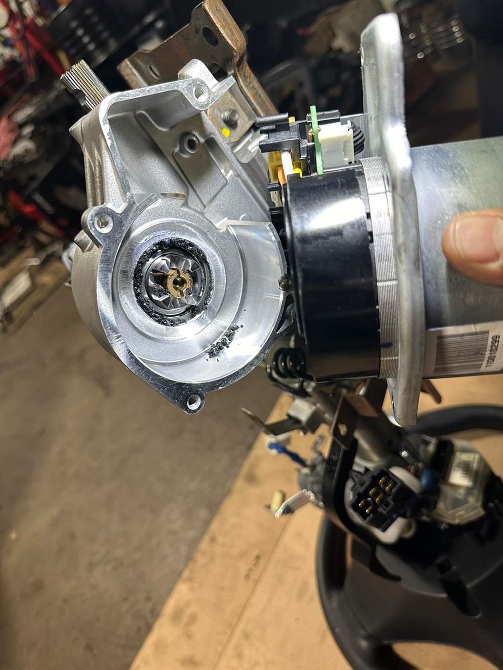 A person is holding a piece of metal that looks like a steering wheel.