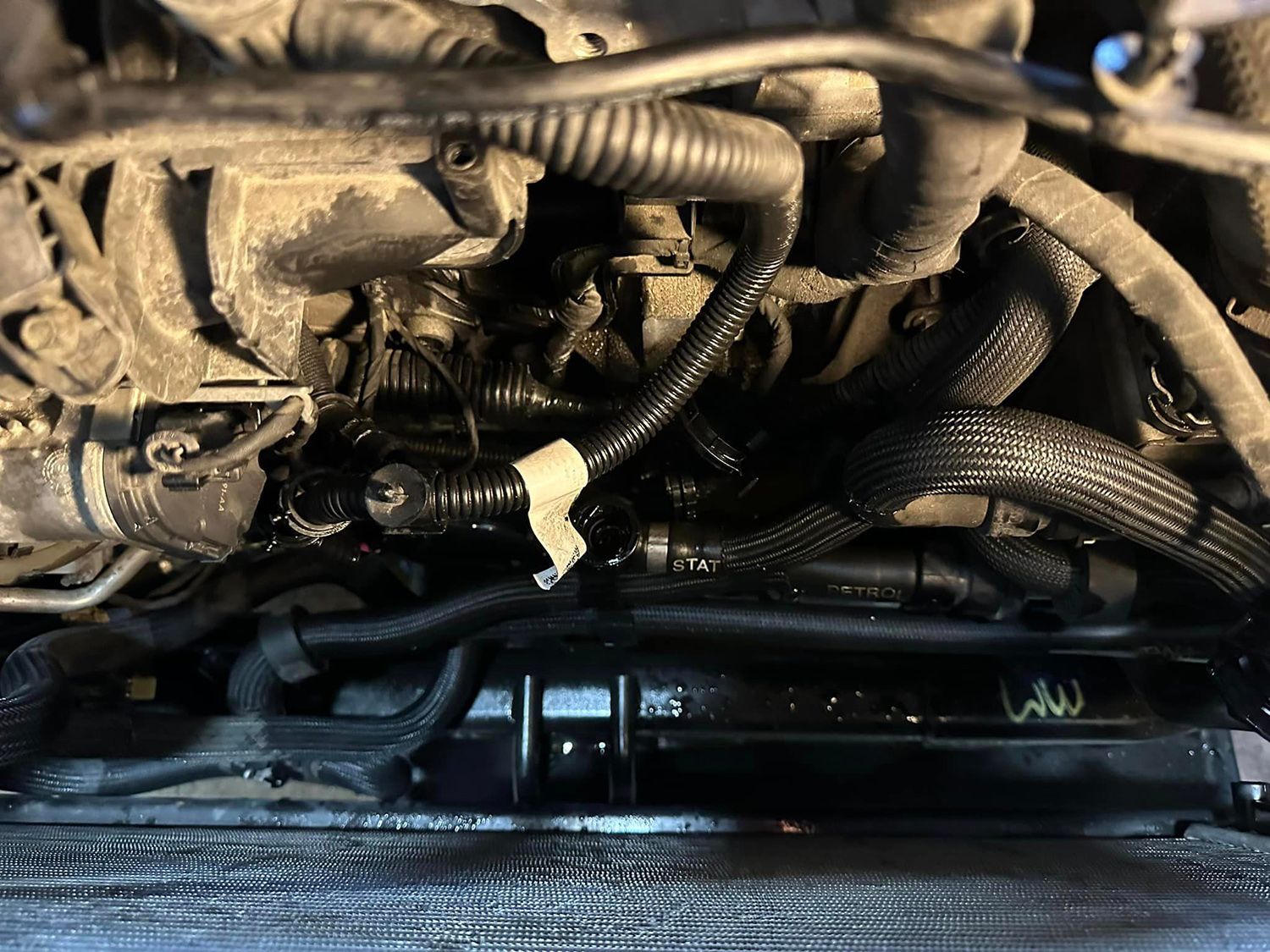 A close up of a car engine with a lot of hose attached to it.