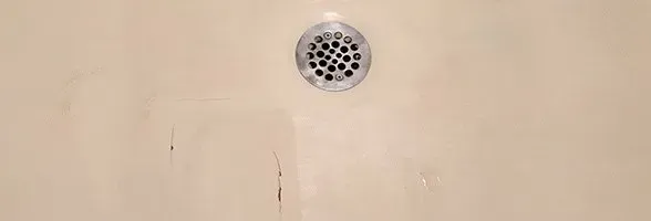 A close up of a shower drain in a bathroom.
