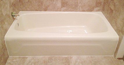 A white bathtub is sitting on a tiled floor in a bathroom.