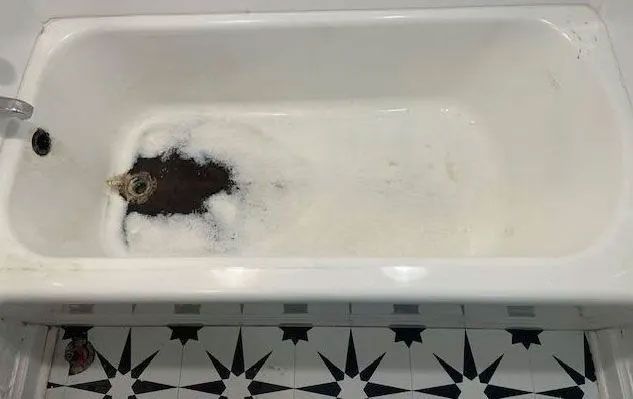 A bathtub filled with foam and bubbles in a bathroom.