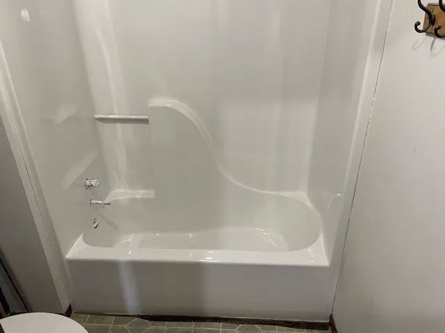 A bathroom with a bathtub and shower stall.