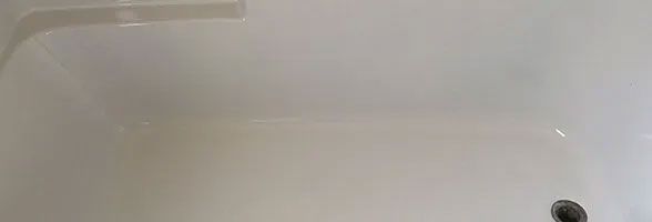 A close up of a white bathtub with water coming out of it.