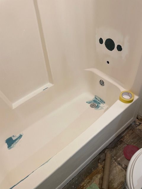 A bathtub is being remodeled in a bathroom next to a toilet.