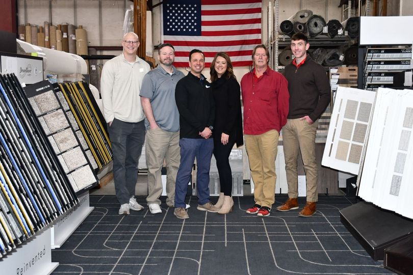 A group of people standing in front of an american flag in a store.