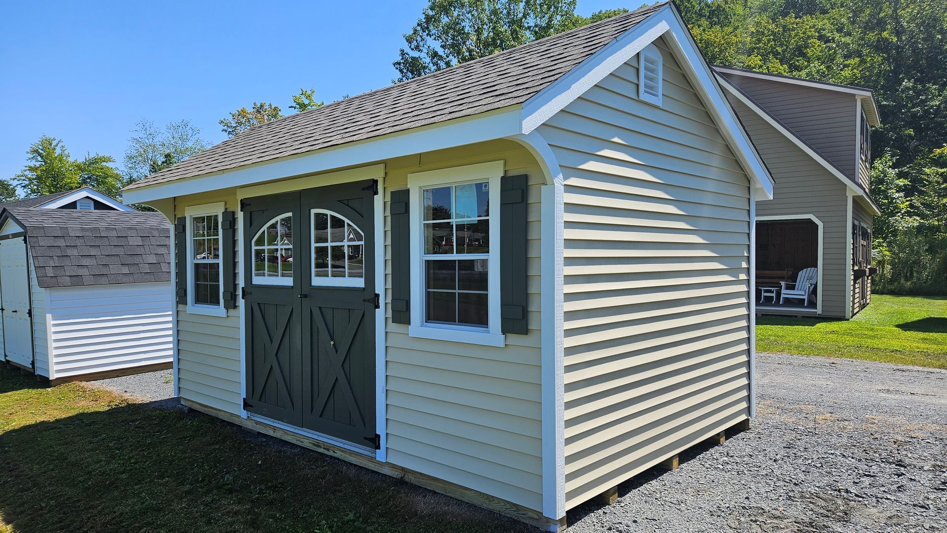 A small shed with a garage in the background.