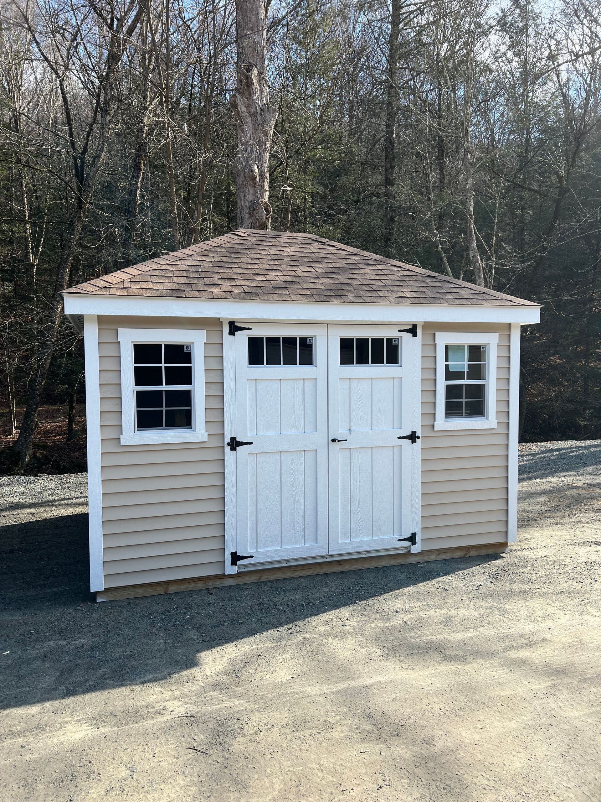 A small shed with a brown roof and white doors