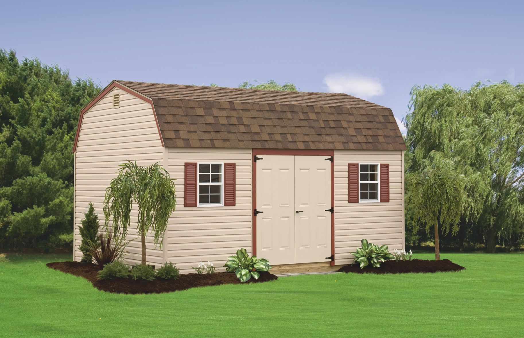 A white barn with brown shutters is in the middle of a lush green field.