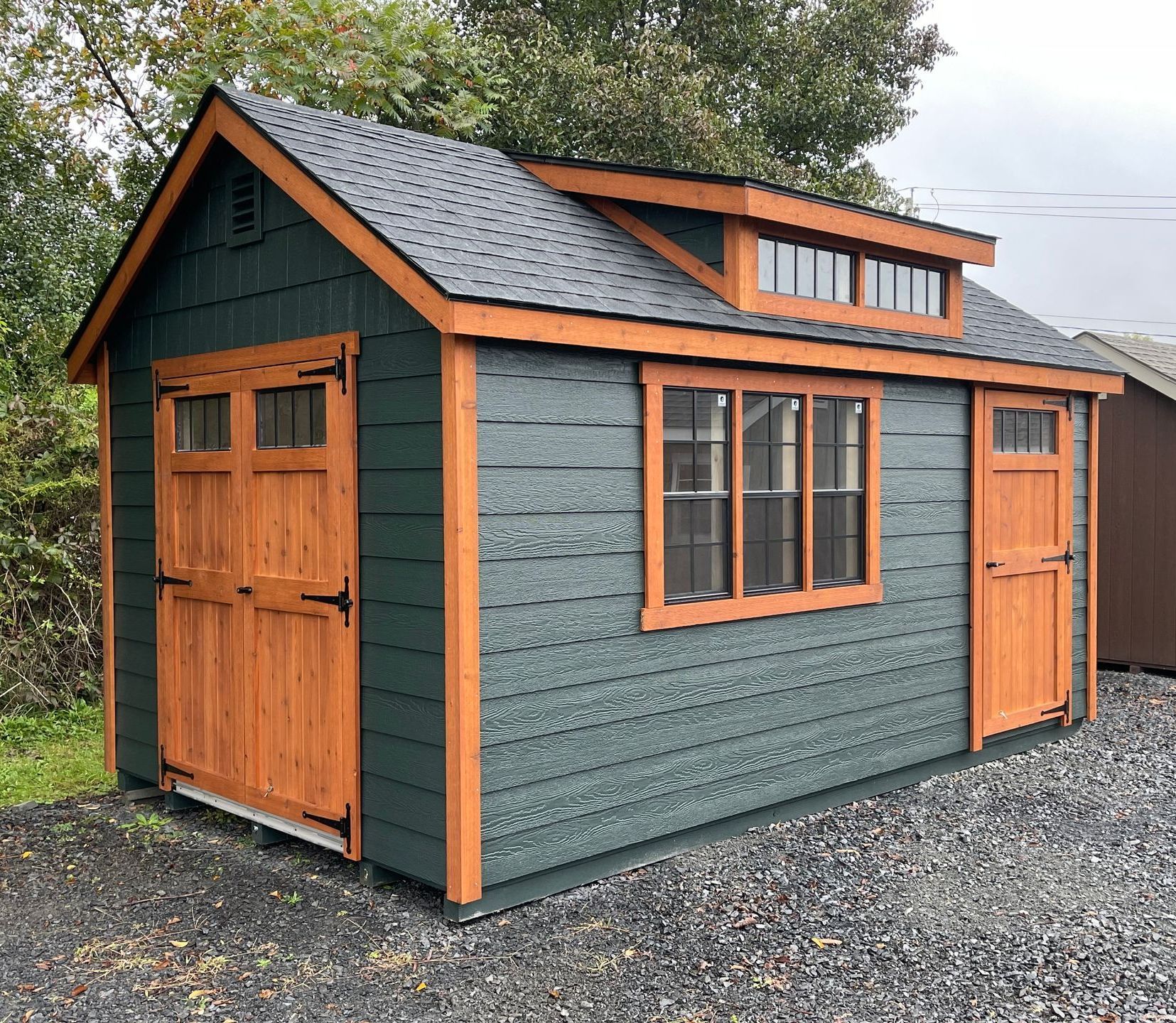 A small shed with a garage door and a window on top of it.