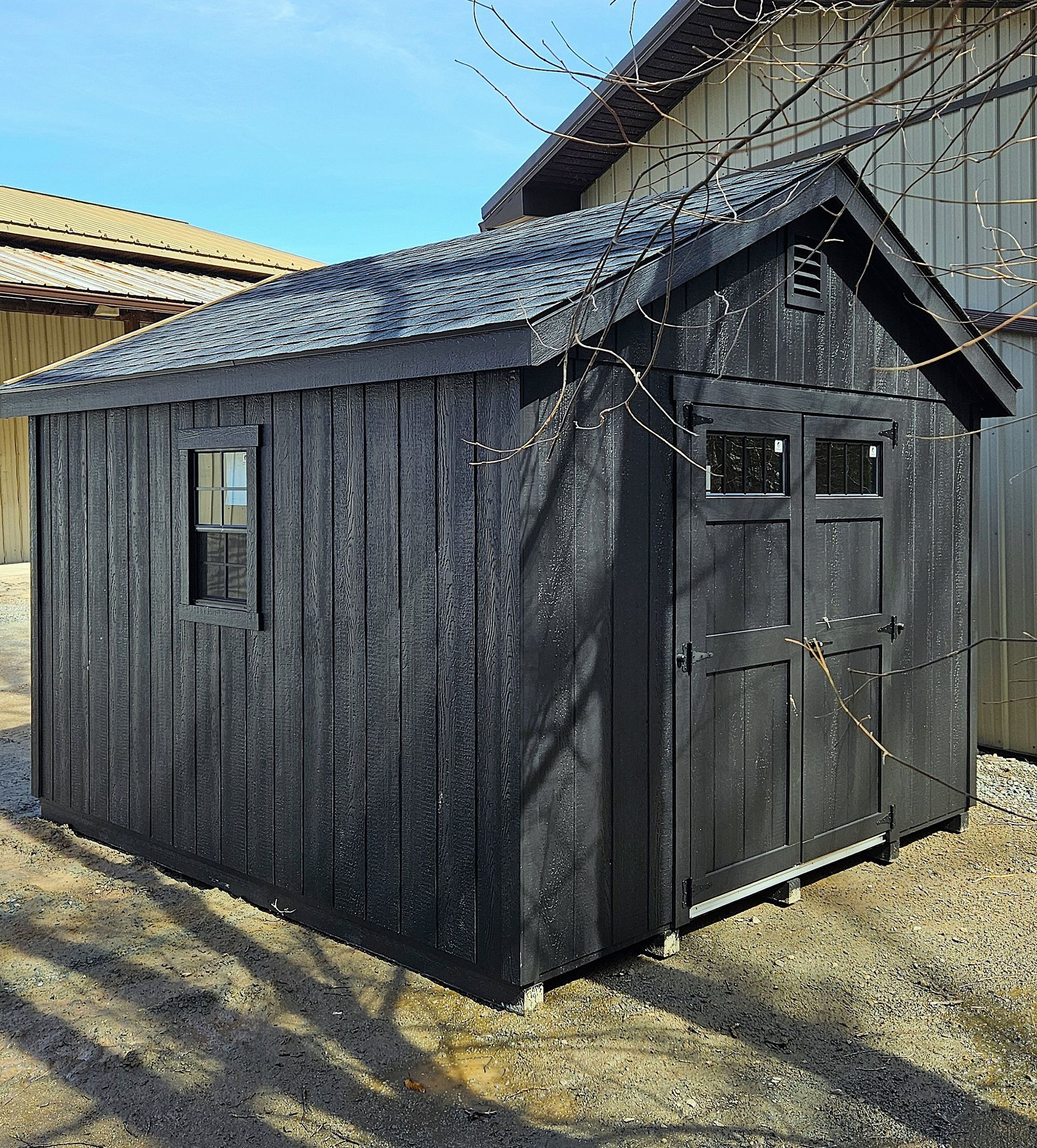 A black shed with a roof and a window