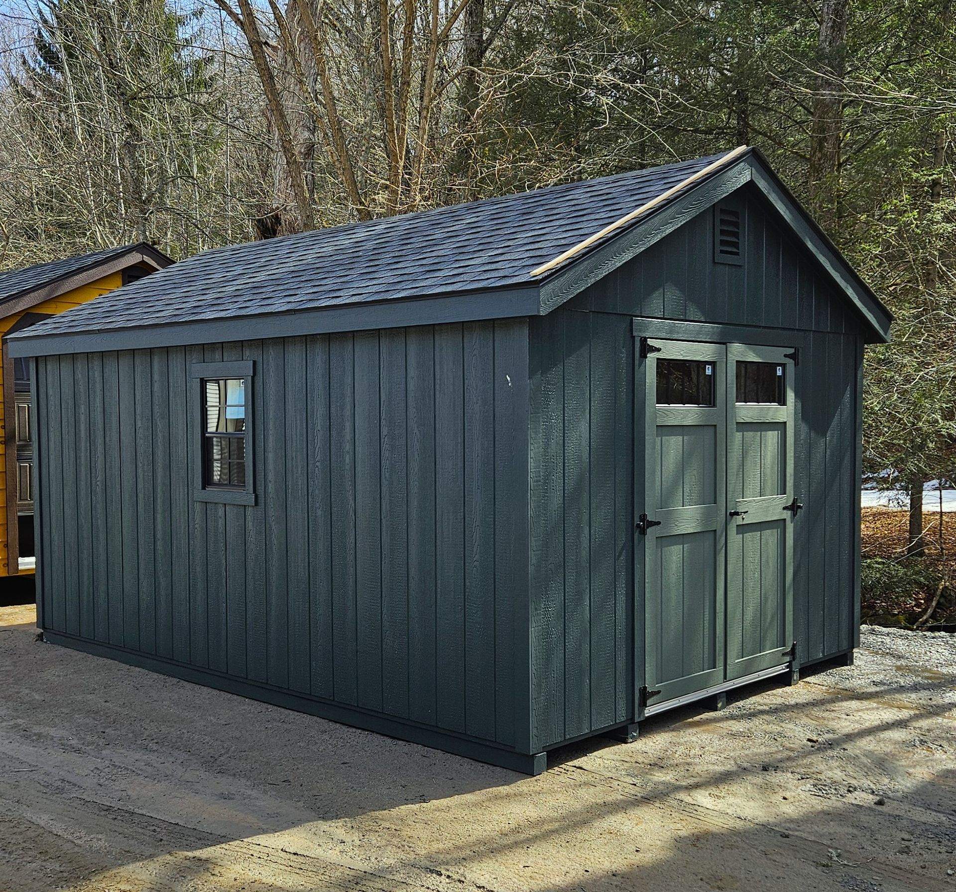 A blue shed with a roof and a window