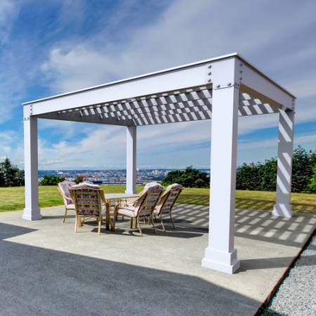 A white pergola with a table and chairs underneath it