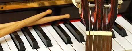 Piano, drum sticks and guitar