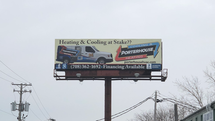 Billboard advertising heating and cooling services above a snowy roadside