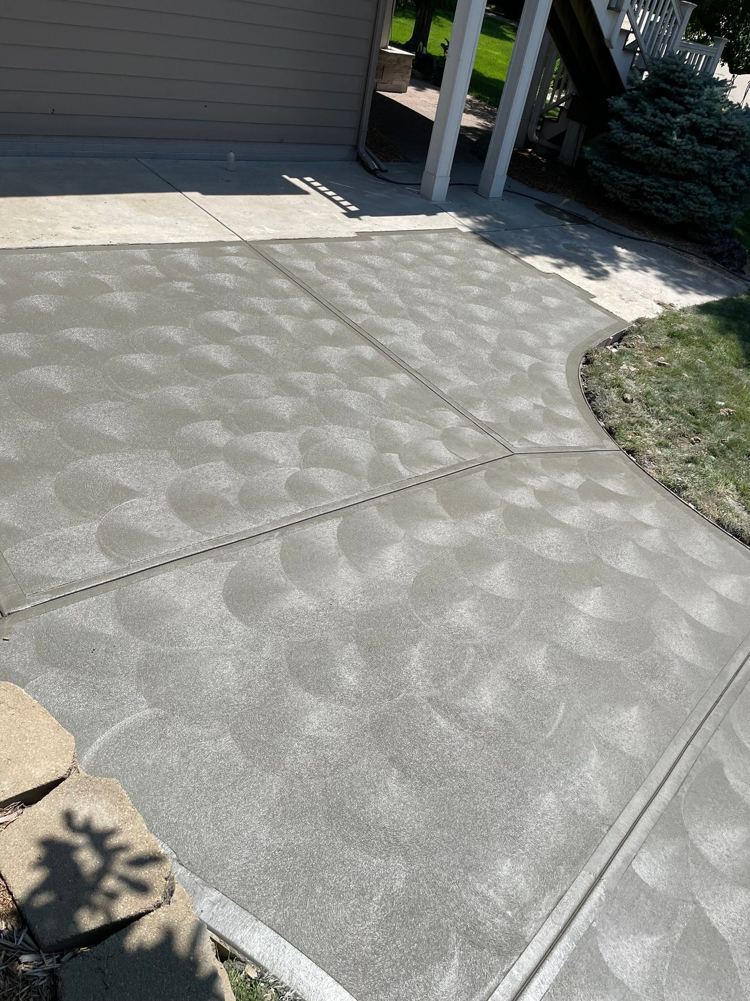 A concrete driveway with a walkway leading to a garage.