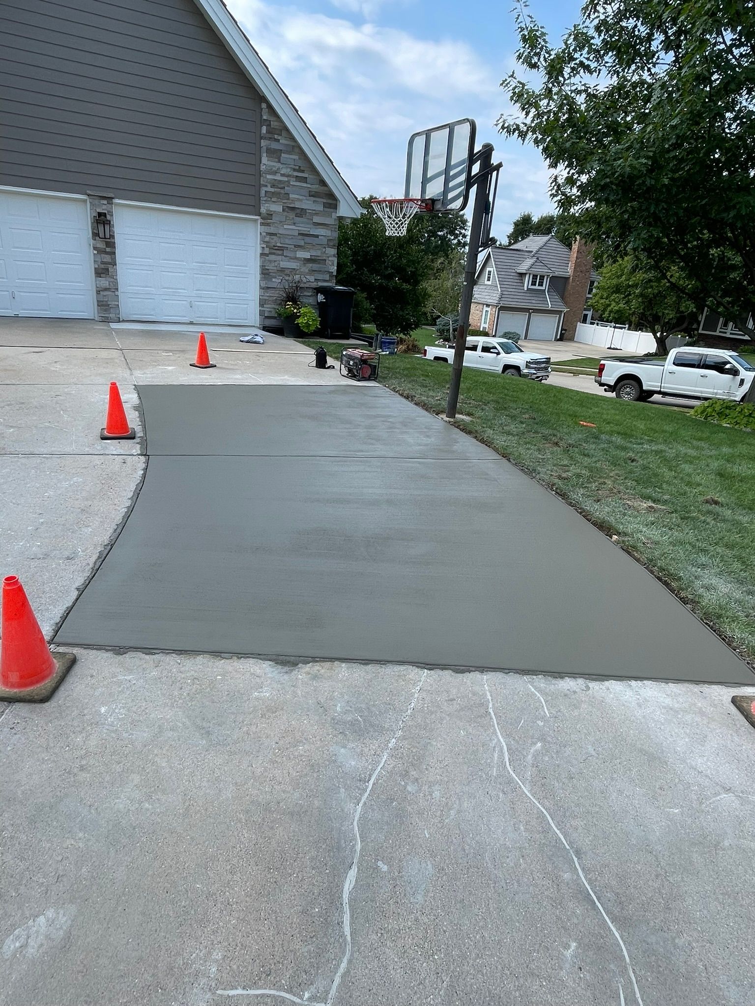 A concrete driveway is being built in front of a house.
