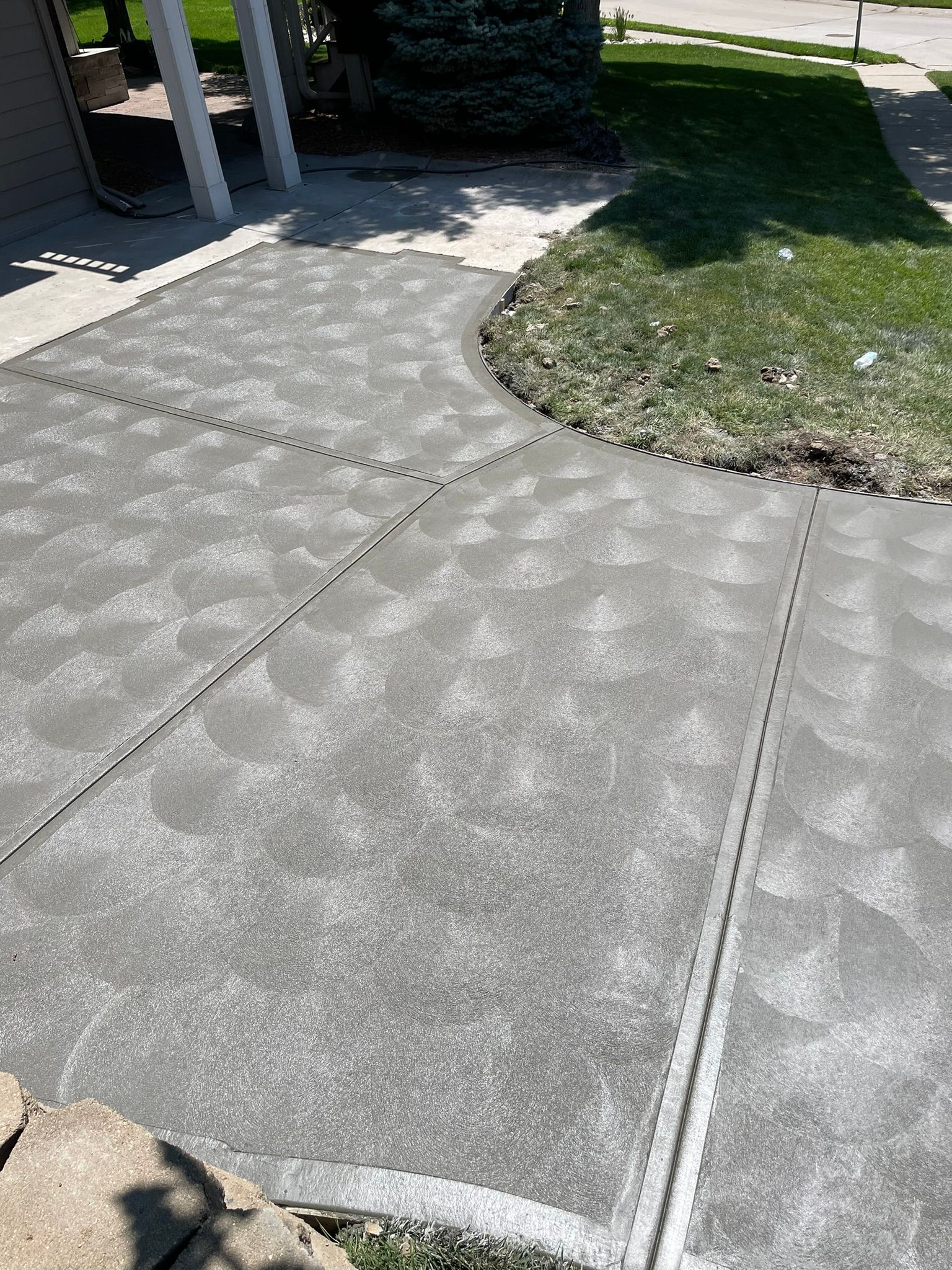 A concrete driveway with a white line on it is being painted.