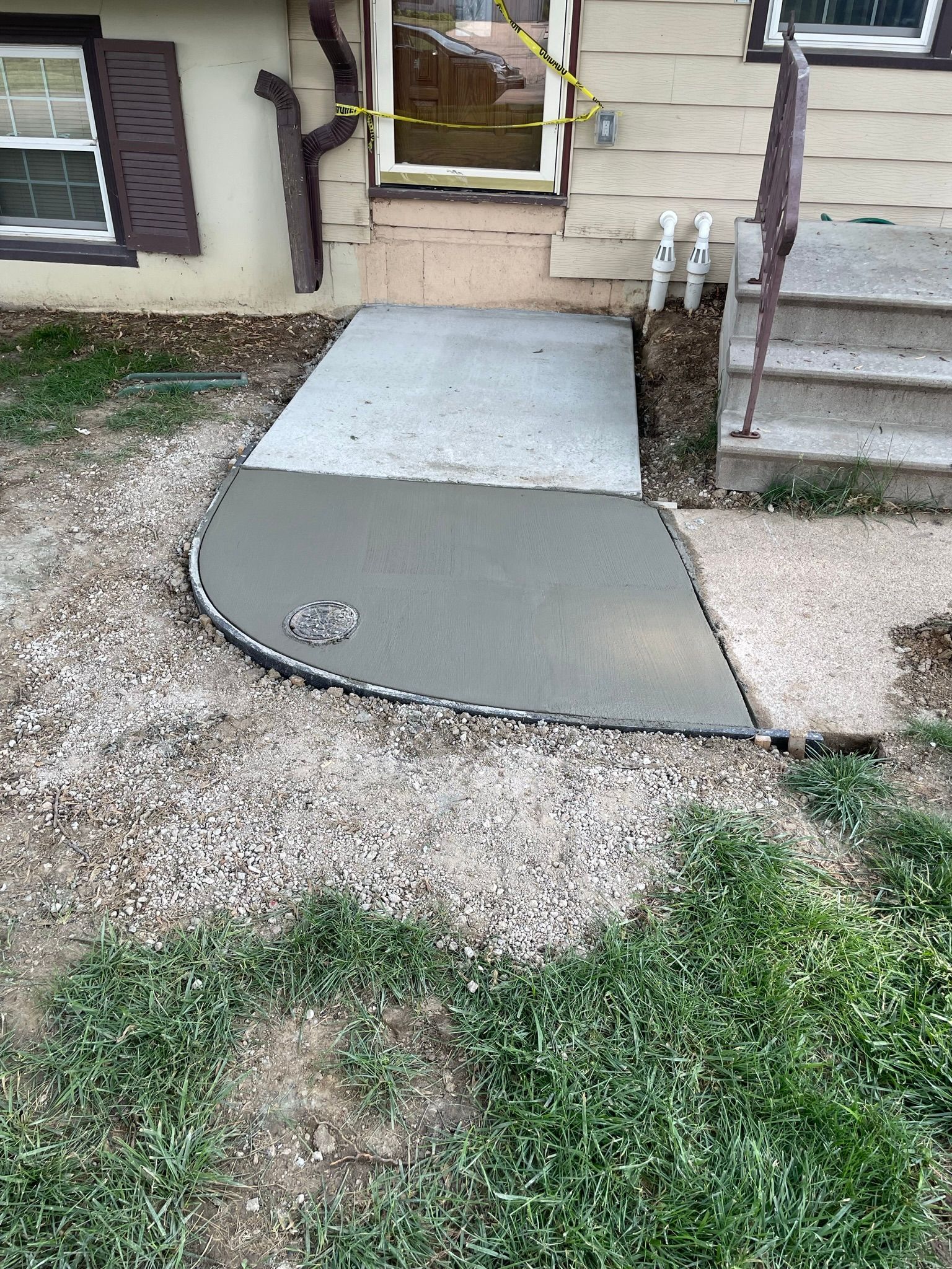 A concrete walkway is being built in front of a house.