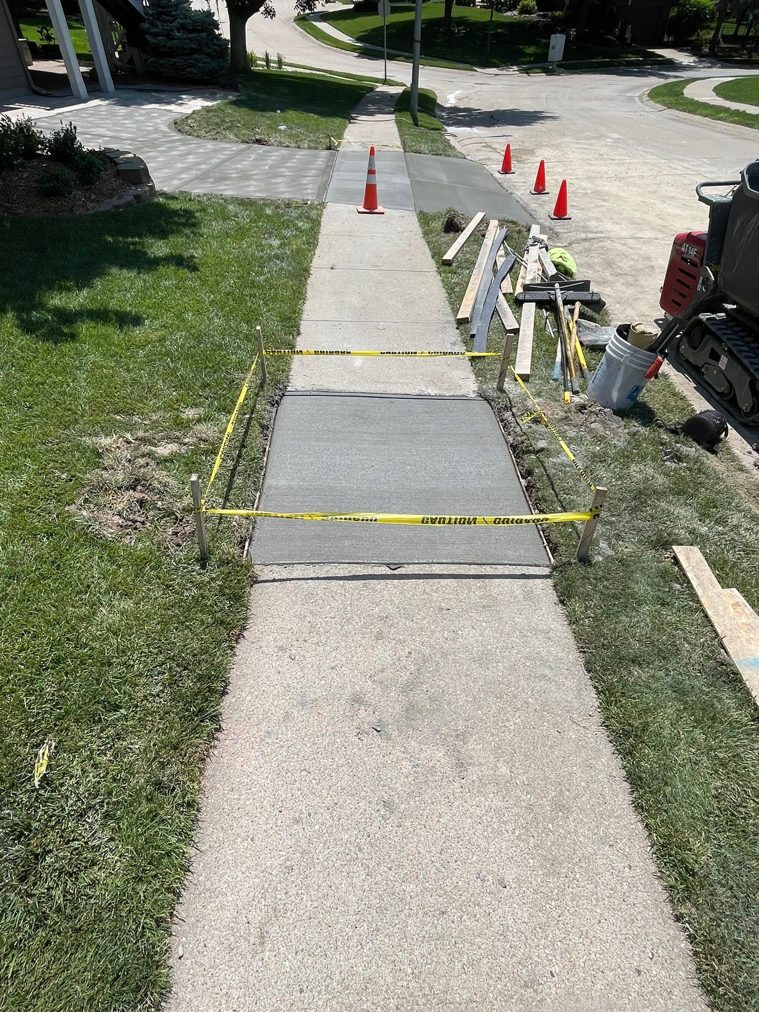 A sidewalk is being built in the grass next to a road.