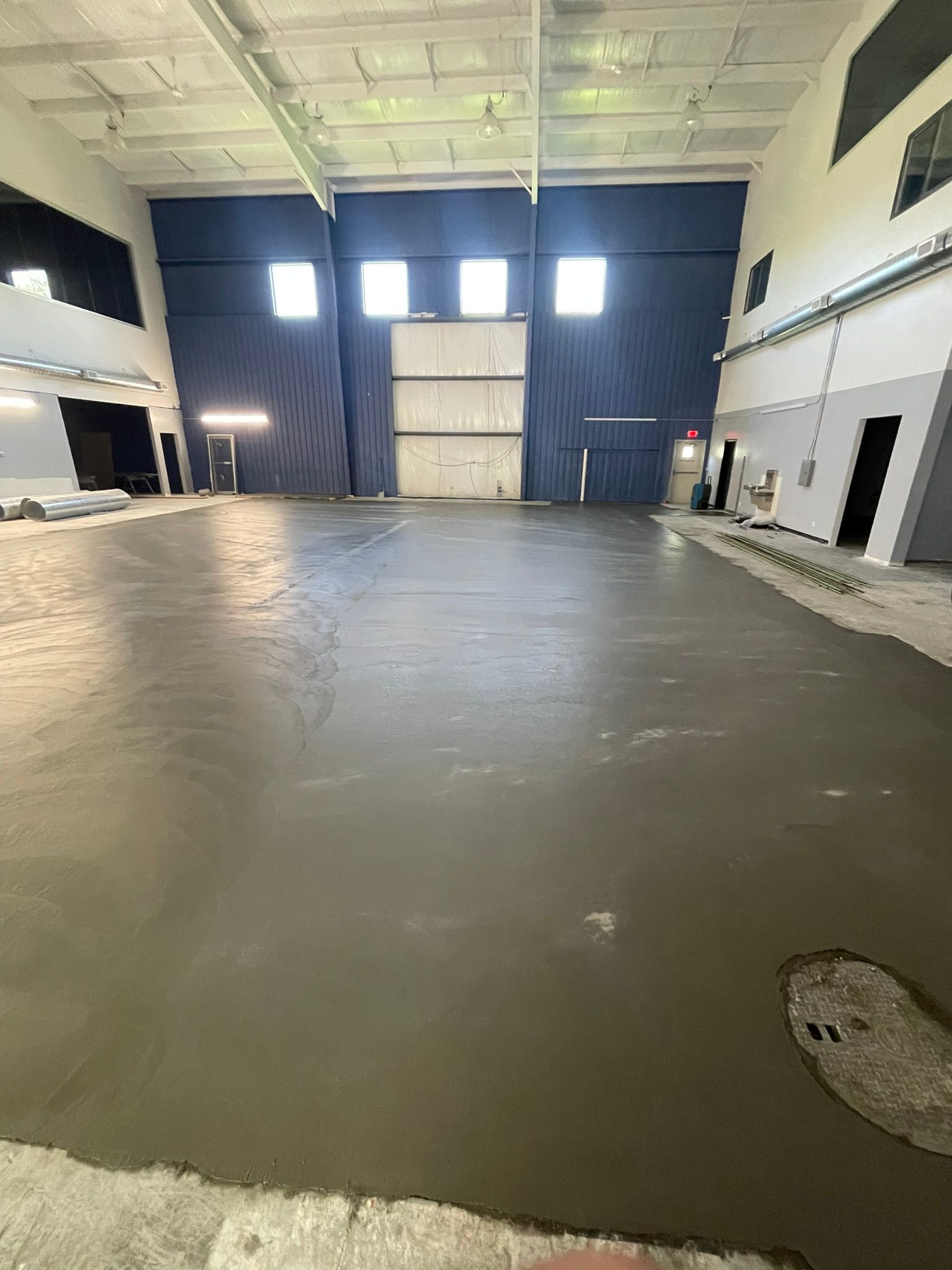 A large warehouse with a concrete floor and a large door.