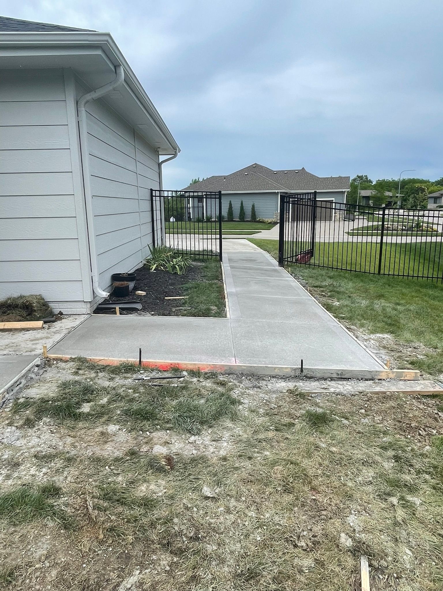 A concrete walkway is being built in front of a house.