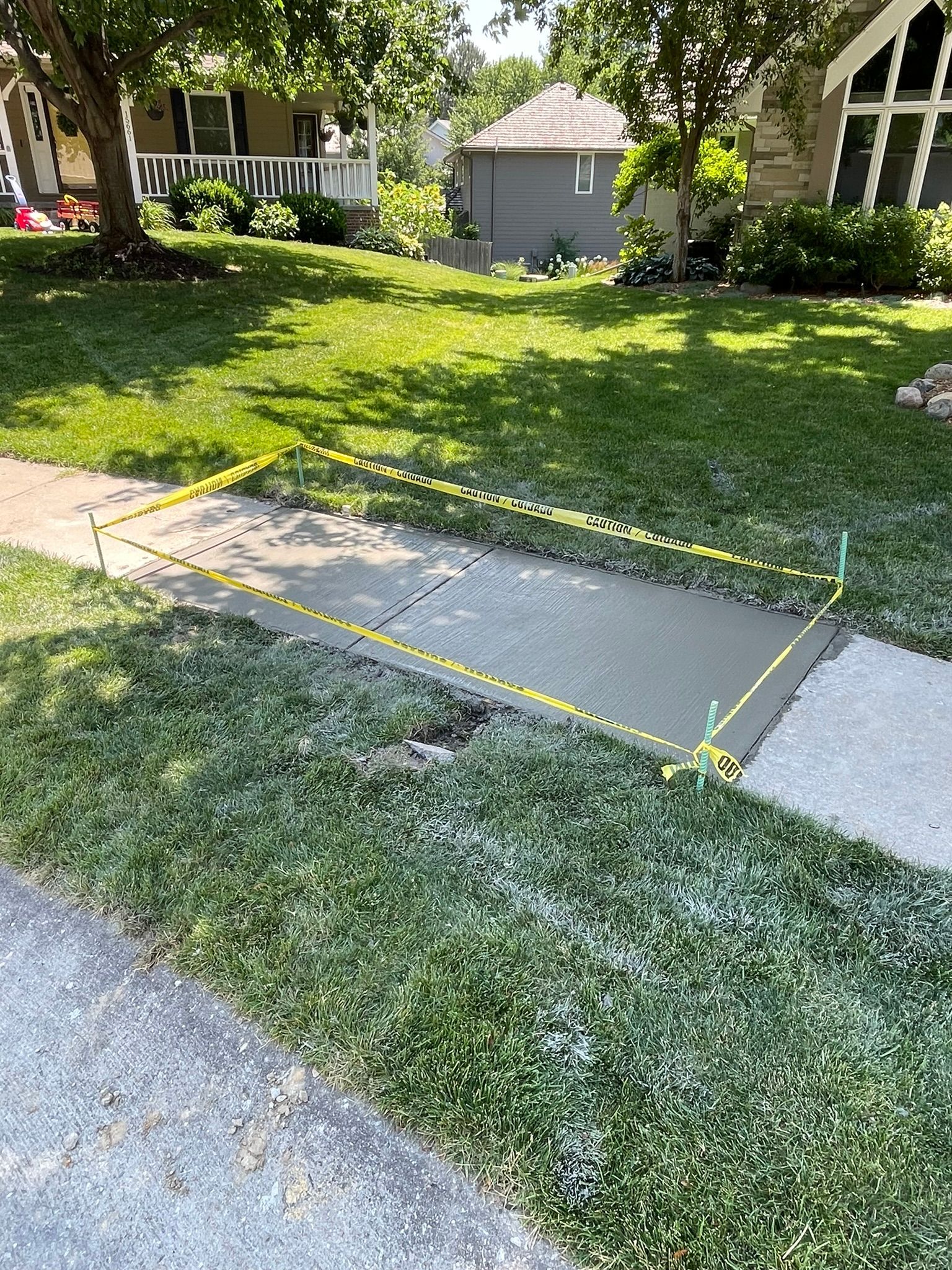 A concrete walkway is being built in front of a house.