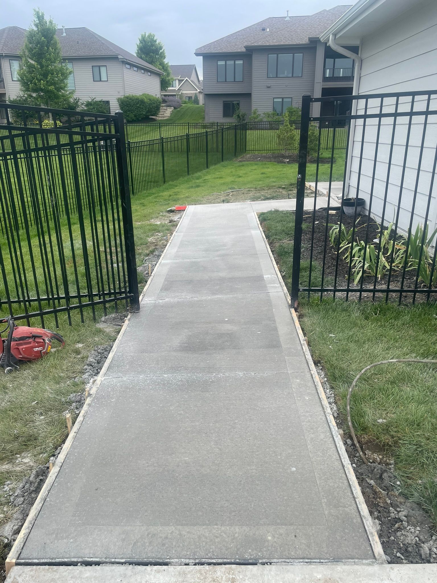 A concrete walkway is being built in front of a house.
